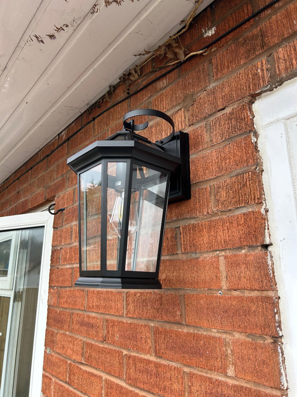 Black exterior wall lantern installed on a brick wall