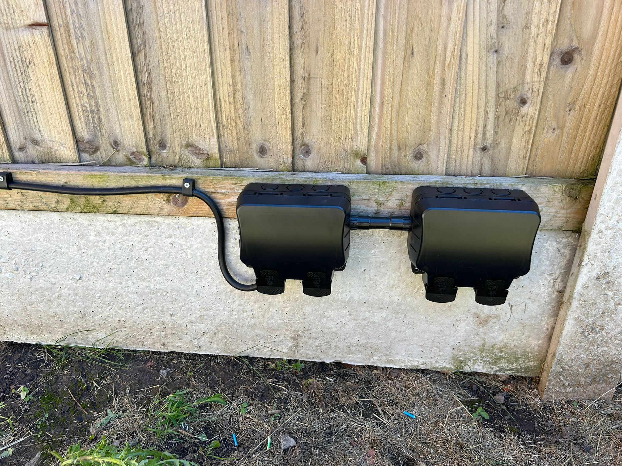 Two weatherproof outdoor socket boxes installed on an exterior wall