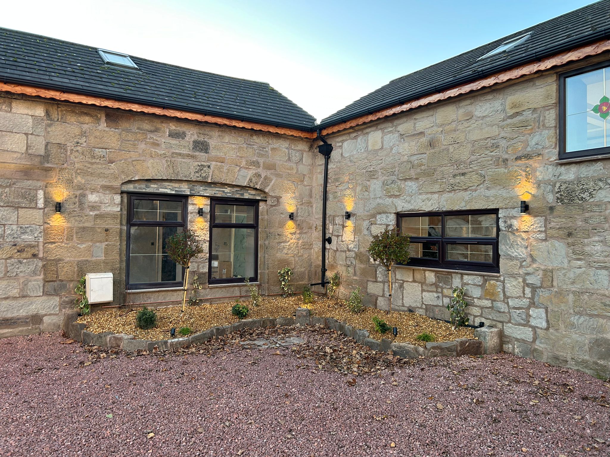 Exterior wall lights fitted to a stone property